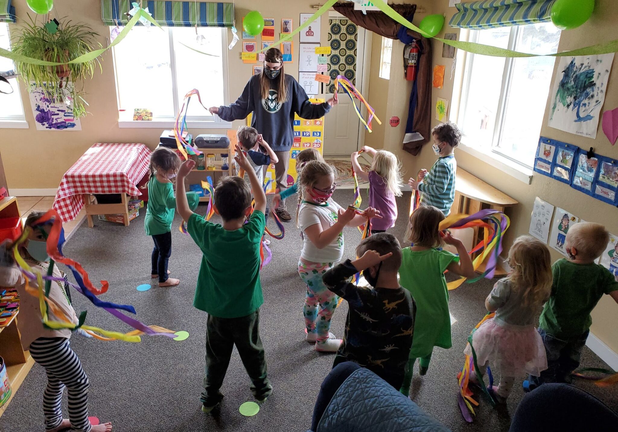 Children and teacher dancing with ribbons.