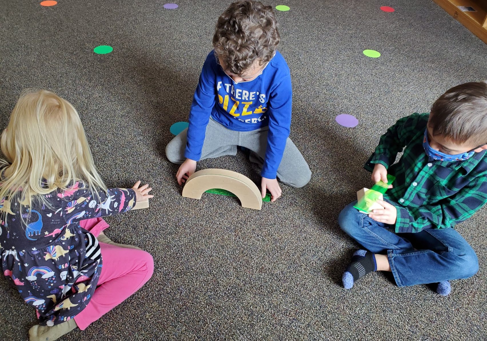 Two boys and a girl measuring blocks.